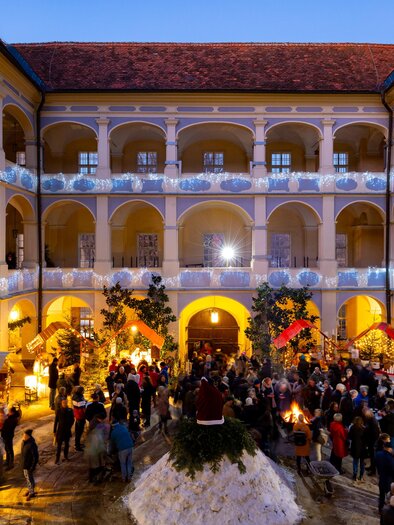 Small wooden huts in the courtyard of Schloss Piber for the sale of crafts and culinary delights, in a pre-Christmas atmosphere. | © Harry Schiffer