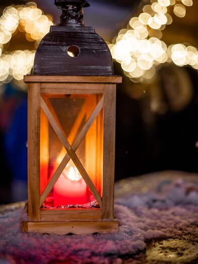 Eine schöne Laterne aus Holz mit warmem Licht. Im Hintergrund sind weiche, verschwommene Lichter sichtbar, die eine gemütliche Atmosphäre schaffen. | © TV Südsteiermark | Stephan Friesinger