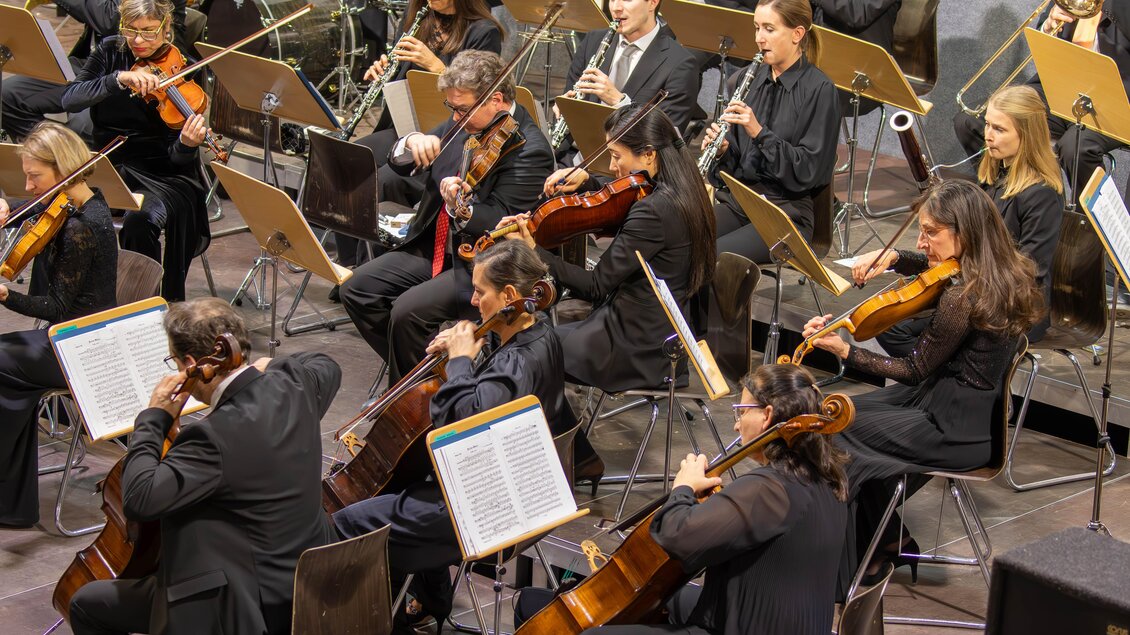 Ein Orchester spielt auf der Bühne. Die Musiker sind in schwarzer Kleidung und konzentriert bei der Aufführung. | © Gemeinde Aigen im Ennstal