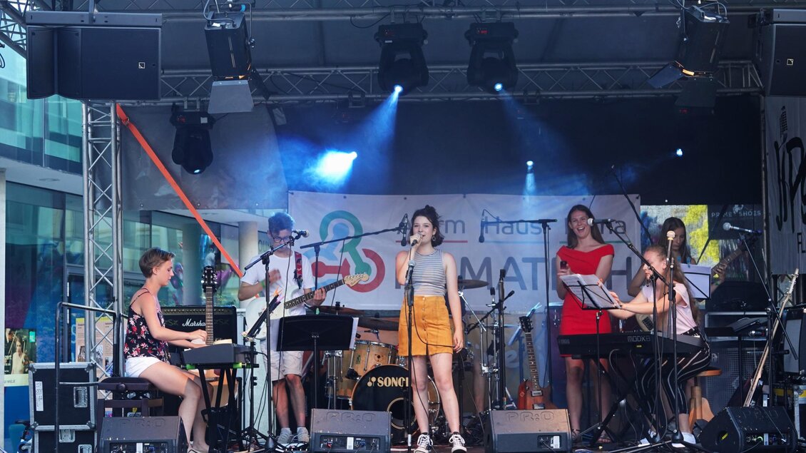 Eine Live-Band spielt auf einer Bühne vor einem Publikum. Die Musikerinnen und Musiker haben Spaß und zeigen ihr Talent. | © Heran