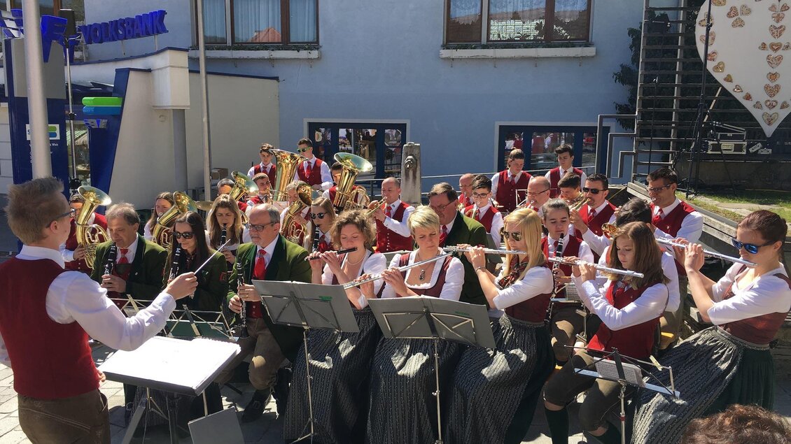 Eine Blaskapelle spielt im Freien, während das Publikum zusieht. Musiker tragen traditionelle Trachten und sind gut gelaunt. | © Oststeiermark Tourismus