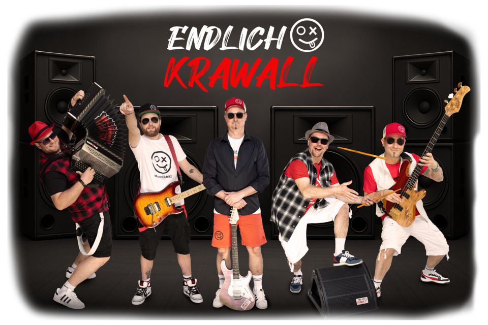 Eine Band steht vor großen Lautsprechern auf einer Bühne. Sie tragen auffällige Outfits und spielen verschiedene Instrumente. | © „ENDLICH-KRAWALL&quot;