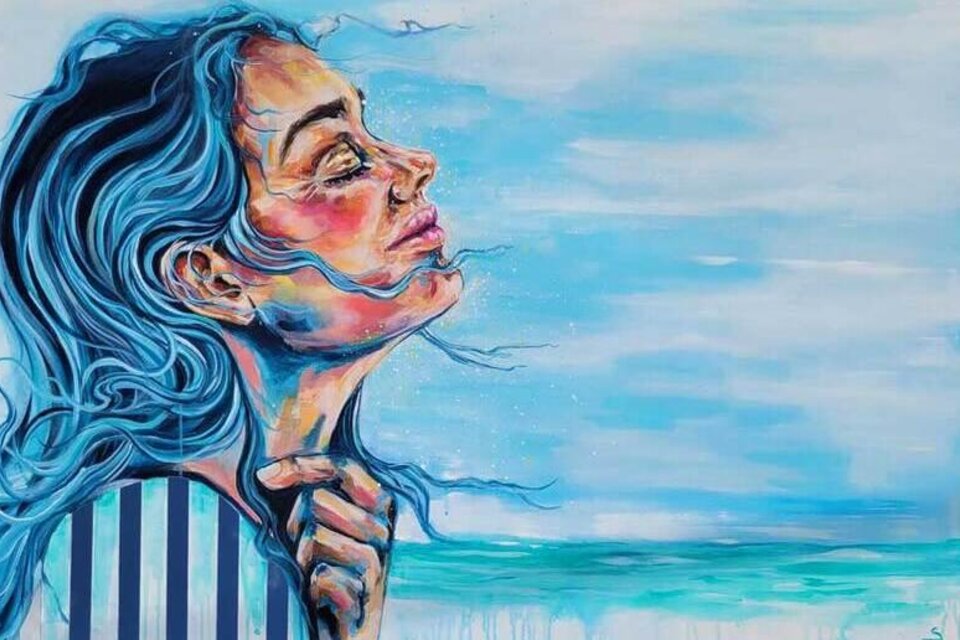 Ein Porträt einer Frau mit langem, blauem Haar, die den Kopf in die Höhe neigt. Im Hintergrund sieht man sanfte Wellen und einen klaren Himmel. | © AndersOrt Haus der Frauen_Oststeiermark