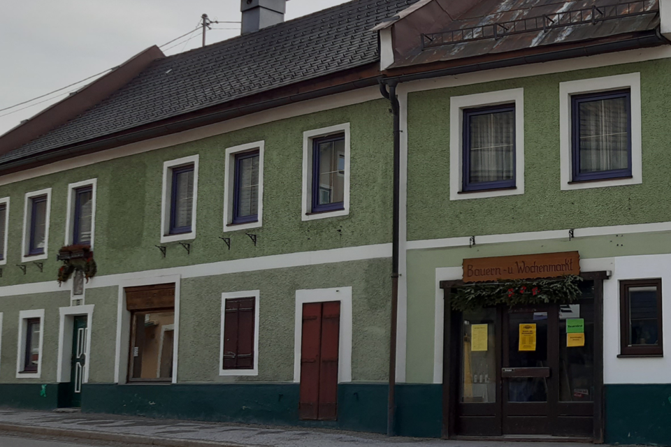 Ein grünes, zweistöckiges Gebäude mit mehreren Fenstern. Die Eingangstür ist geschmückt und zeigt an, dass ein Restaurant geöffnet ist. | © Daniela Casari