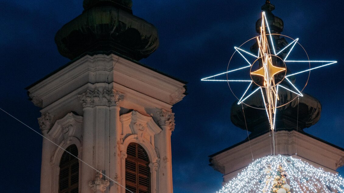Kirchtürme Mariahilferkirche mit leuchtenten Weihnachtsstern im Vordergrund | © Region Graz - Studio draussen