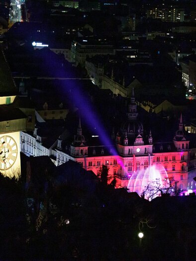 <p>Silversternacht Blick auf den beleuchteten Grazer Schlossberg und das in pink beleuchtete Rathaus aufgrund des Silvesterspektakels</p> | © Iventents Kulturagentur - Erwin Scheriau