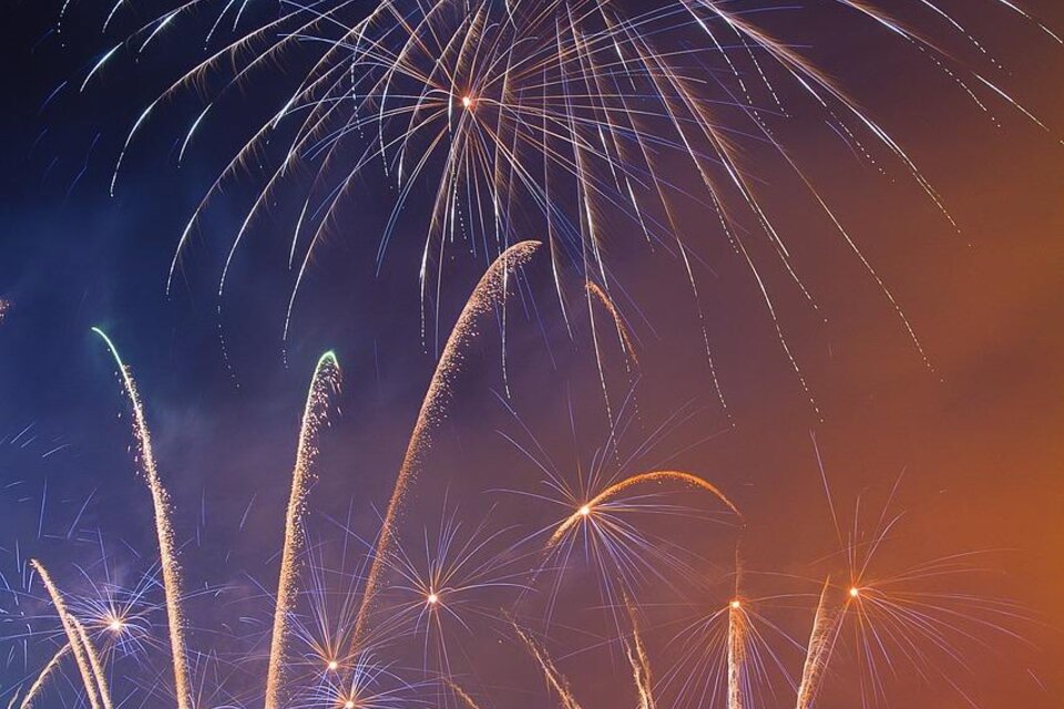 Ein buntes Feuerwerk erleuchtet den Nachthimmel. Silhouetten von Menschen sind im Vordergrund zu sehen. | © Pixabay