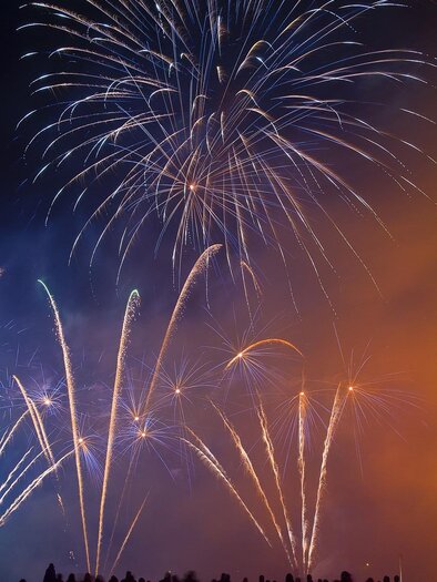 Ein buntes Feuerwerk erleuchtet den Nachthimmel. Silhouetten von Menschen sind im Vordergrund zu sehen. | © Pixabay