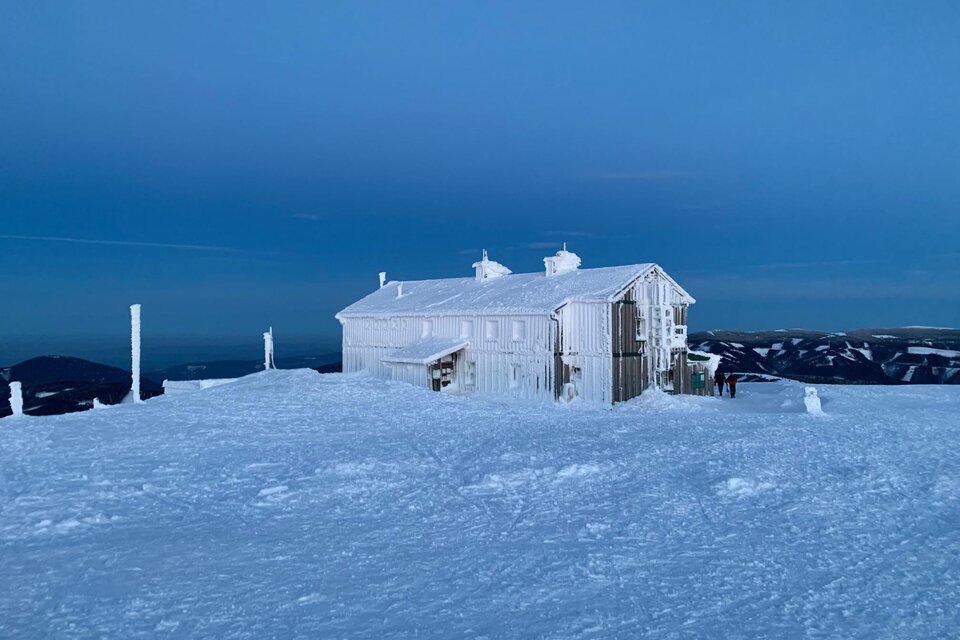 Ein weißes Gebäude steht in einer schneebedeckten Landschaft unter einem klaren, blauen Himmel. Die Umgebung ist ruhig und winterlich. | © Martin Ziegerhofer