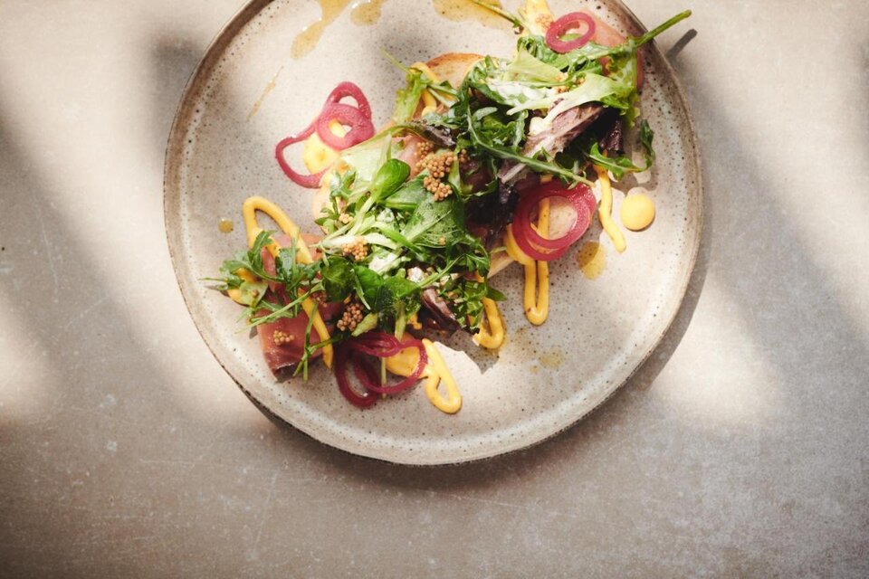 Ein kunstvoll angerichteter Teller mit frischen Zutaten. Darauf liegen fleischige Stücke, garniert mit buntem Gemüse und Saucen. | © Das Zeitwert