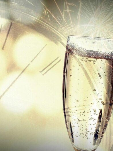 Two glasses of sparkling wine toast, while in the background a clock and fireworks are visible. The atmosphere is festive and celebratory. | © Pixabay