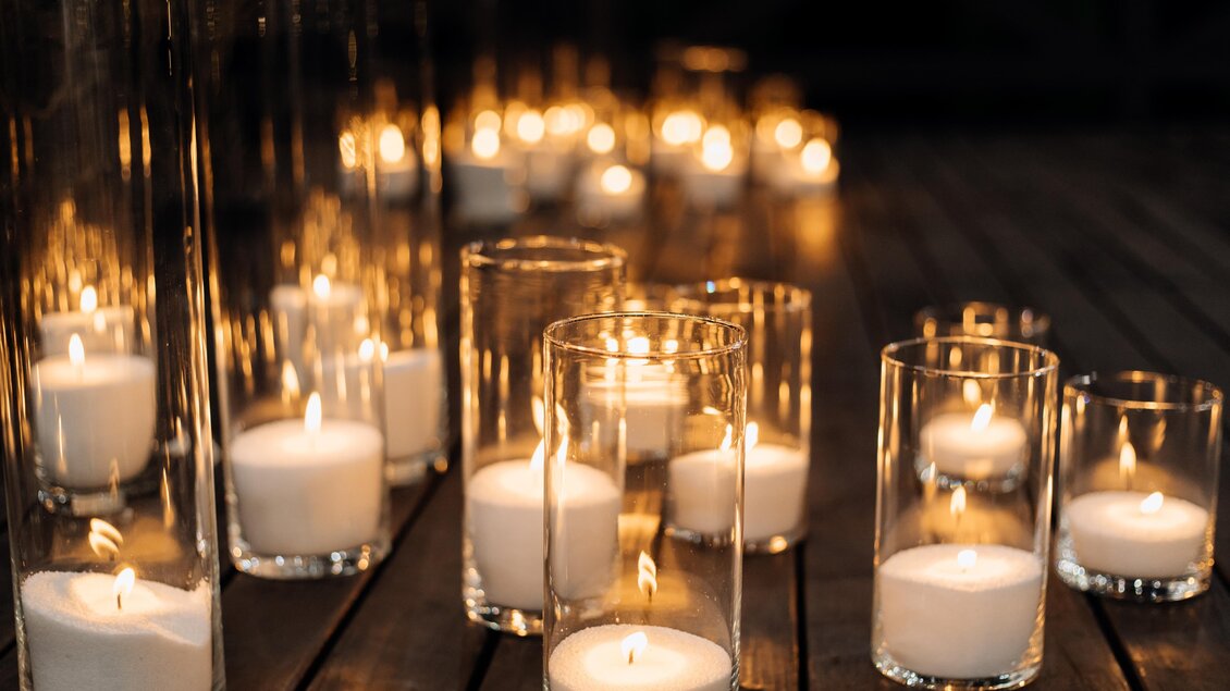 Eine romantische Anordnung von Kerzen in Glasbehältern. Sanftes Licht schafft eine gemütliche Atmosphäre. | © MALU