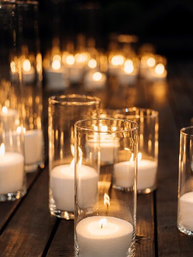 A romantic arrangement of candles in glass containers. Soft light creates a cozy atmosphere. | © MALU