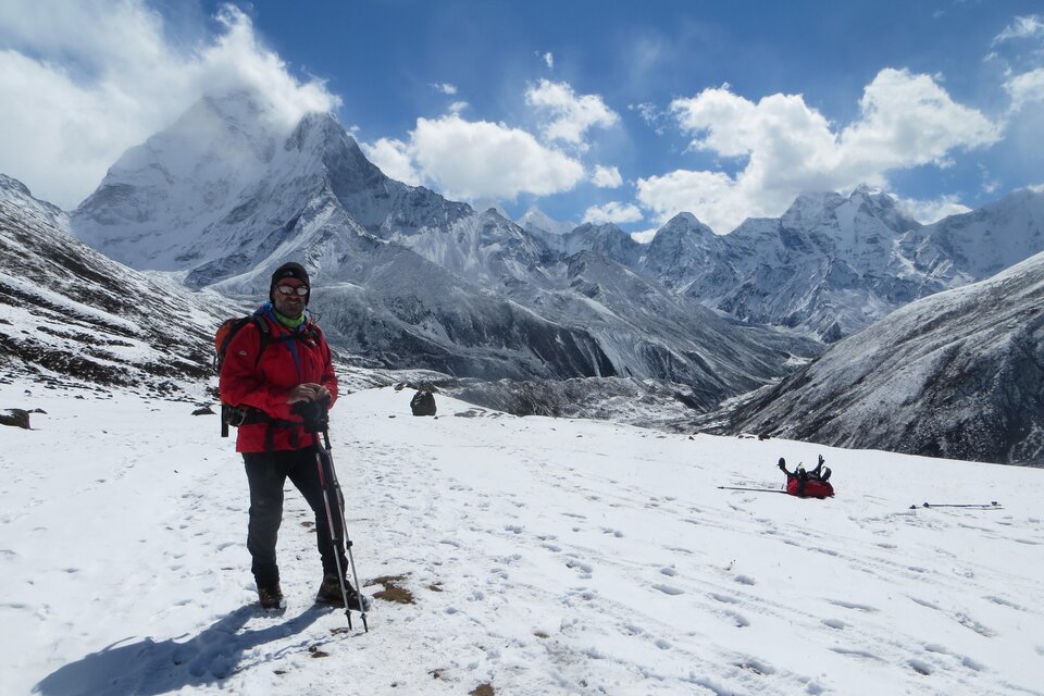 Ein Wanderer steht im Schnee vor majestätischen Berggipfeln. Der Himmel ist klar und sonnig mit einigen Wolken. | © Kager Eduard