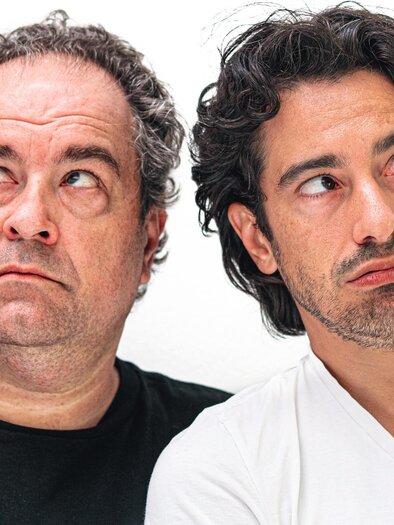 Two men with a thoughtful expression are looking to the side. The man on the left is wearing a black T-shirt, and the man on the right is wearing a white T-shirt. | © © f6theopenfactory