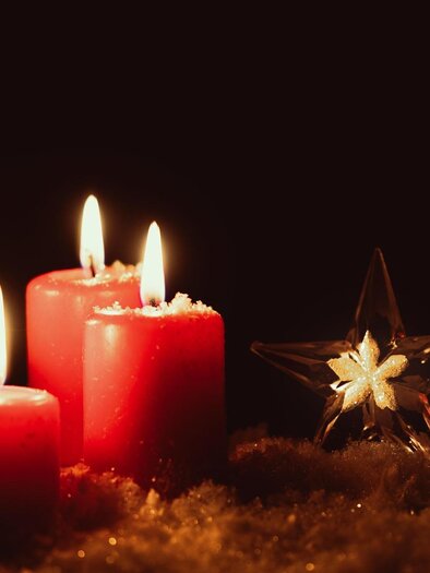 Four red candles burn gently in the dark. Next to them stands a clear, glittering star. | © pixabay.com