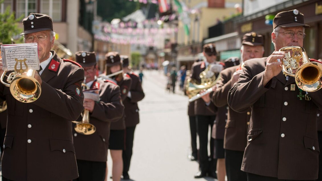 Eine Blaskapelle spielt in einer festlichen Straße. Die Musiker tragen traditionelle Trachten und haben Instrumente in der Hand. | © Narzissenfestverein/St. Pelizzari