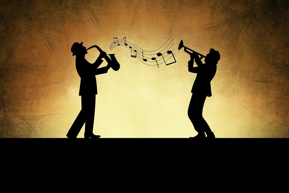 Zwei Silhouetten von Musikern, die Saxophon und Trompete spielen. Noten schweben über ihnen vor einem warmen, goldenen Hintergrund. | © Pixabay