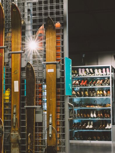 An exhibition room with old skis on the wall. In the background, there is a poster of a skier. | © Nicole Seiser, nicoleseiser.at