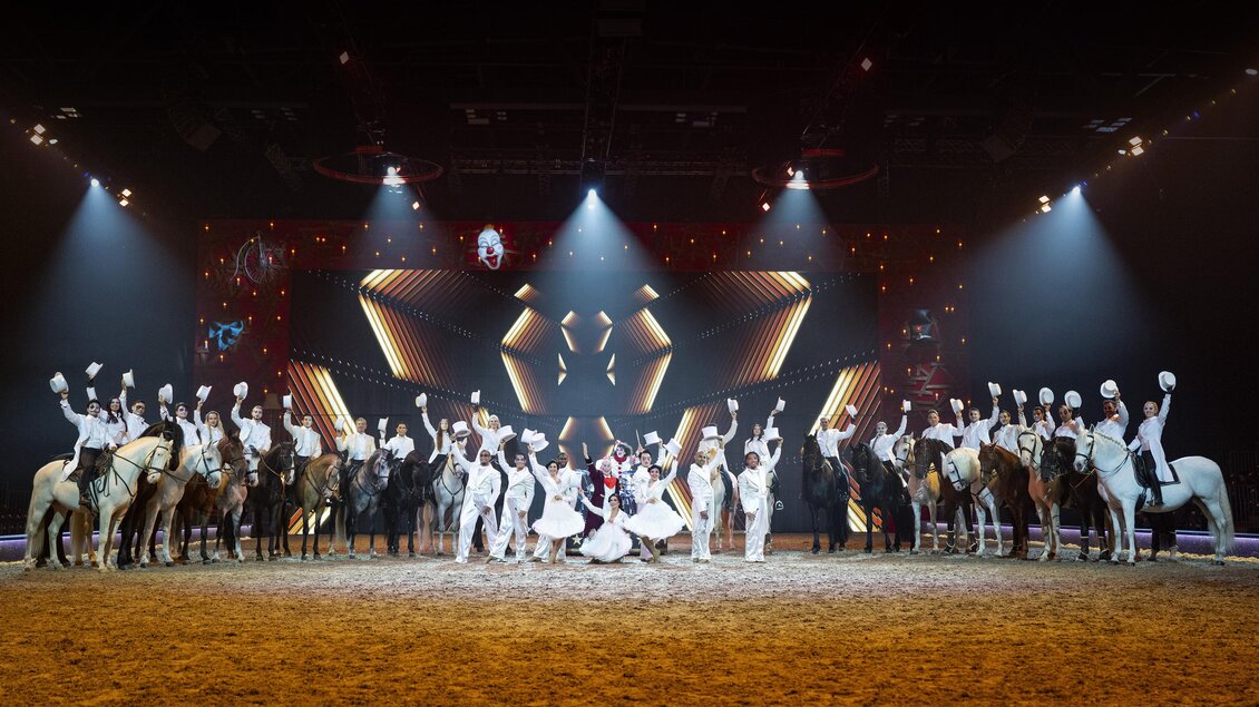 Eine beeindruckende Aufführung mit Pferden und Reiterinnen auf einer Bühne. Die Künstler präsentieren synchronisierte Bewegungen unter bunten Lichtern. | © @CAVALLUNA
