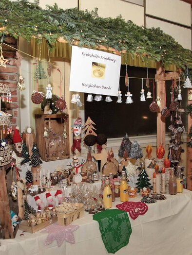 Ein festlicher Marktstand mit handgefertigten Weihnachtsdekorationen. Der Stand ist mit Tannenzweigen dekoriert und zeigt eine Vielzahl von Kunsthandwerk und Weihnachtsartikeln. | © Vereinsgemeinschaft Ehrenschachen