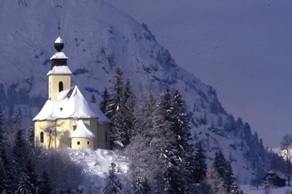 Eine hübsche Kirche inmitten schneebedeckter Berge und Tannen. Die friedliche Winterlandschaft strahlt Ruhe aus. | © TVB Ausseerland Salzkammergut_Pirker