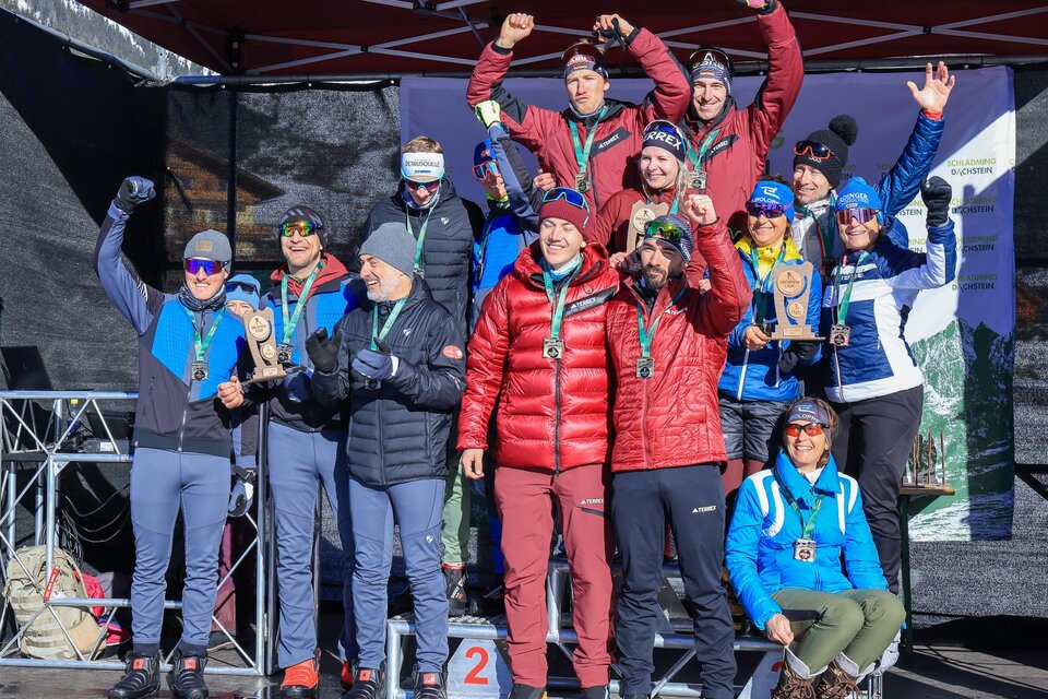 Eine Gruppe von Menschen steht auf dem Siegertreppchen und feiert mit Medaillen. Die Atmosphäre ist festlich und sportlich, im Hintergrund ist eine Zeltkonstruktion erkennbar. | © Michael Simonlehner