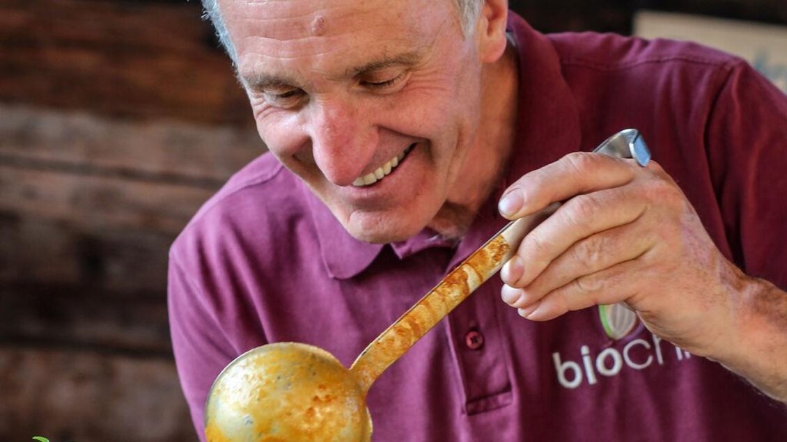 Ein Koch serviert frisch zubereitete Speisen. Die warme, herzliche Atmosphäre passt perfekt zur natürlichen und hochwertigen Verpflegung des Festivals. | © Das Bergyogafestival