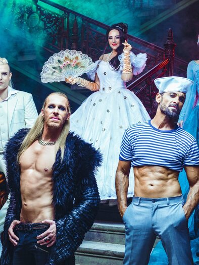 A group of people in imaginative costumes posing in a mystical space. The scene has dramatic lighting and conveys a fairy-tale atmosphere. | © Die Nacht der Musicals