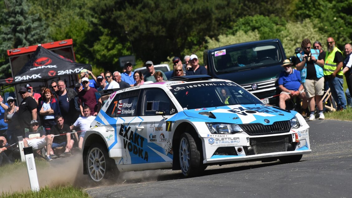 Ein Rennwagen fährt dicht an einem Zuschauerfeld vorbei. Es ist ein sonniger Tag mit vielen Menschen, die das Rennen beobachten. | © Peter Hopf