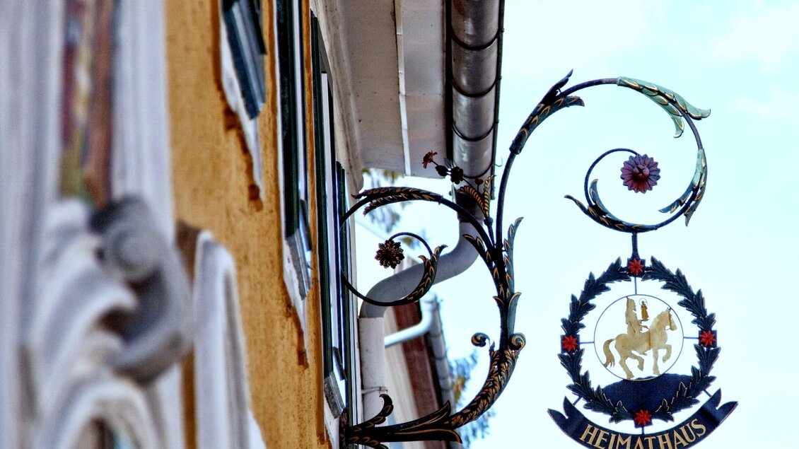 Ein schön gestaltetes Schild mit dem Schriftzug "Heimathaus". Es ist an einer Wand angebracht und zeigt ein dekoratives Design. | © TV Hochsteiermark