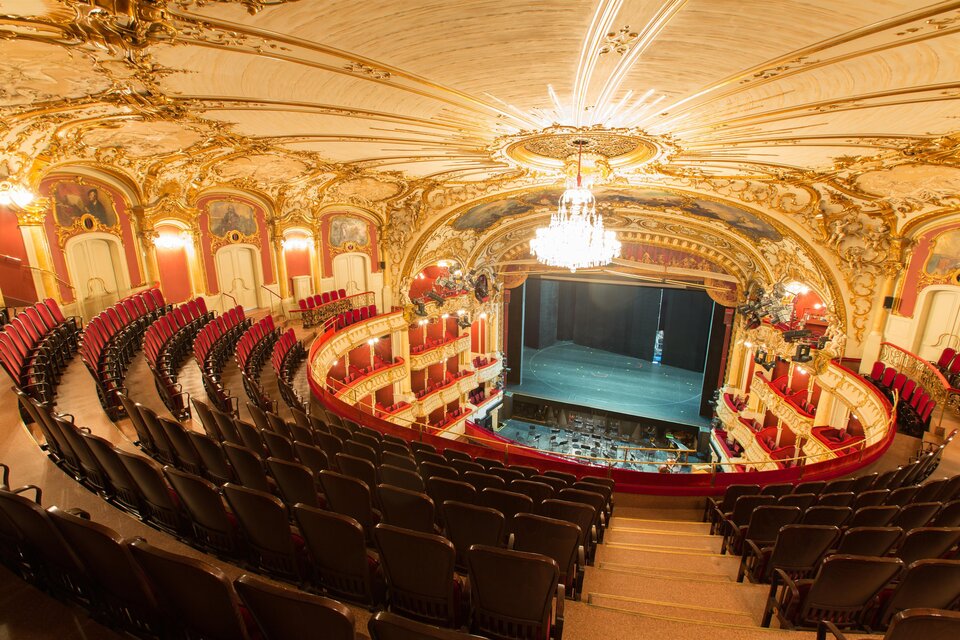 Ein elegantes Theater mit prunkvollem Interieur und rotem Sitzbereich. Die Bühne ist vorbereitet und wartet auf die nächste Vorstellung. | © (c) Graz Tourismus - Harry Schiffer