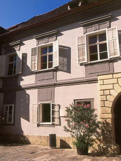 A historic building with shutters and a large gate. The facade displays a charming mix of traditional and modern architectural elements. | © Museum im alten Zeughaus
