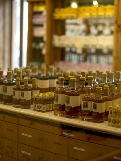 Eine Auswahl von Flaschen auf einem Tisch in einem Laden. Im Hintergrund sind Regale mit weiteren Produkten sichtbar. | © Steiermark Tourismus