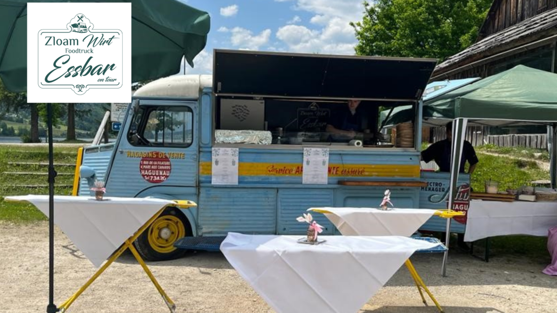 Ein hübscher Foodtruck in Blau, der frische Speisen anbietet. Vor dem Truck stehen Tische, die für Gäste vorbereitet sind. | © Narzissendorf Zloam, www.zloam.at