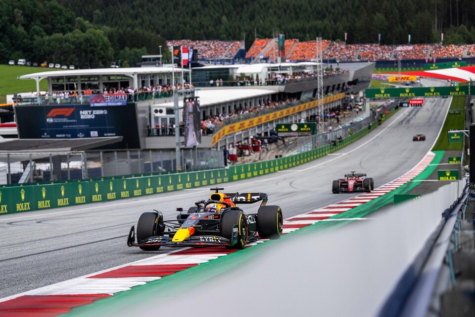 Ein Formel-1-Rennwagen fährt auf der Rennstrecke, umgeben von einer lebhaften Zuschauermenge. Im Hintergrund sind die pit lane und die Berge zu sehen. | © Joerg Mitter Red Bull Ring