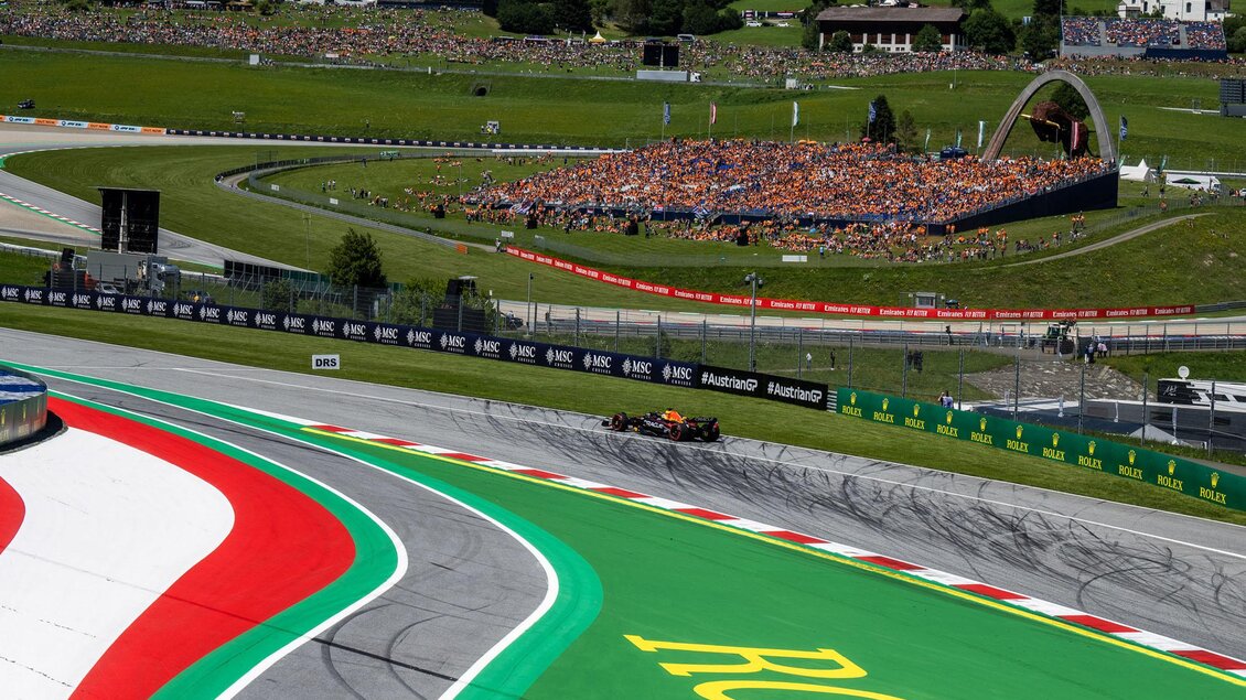 Ein Formel-1-Rennwagen fährt über eine kurvenreiche Strecke. Im Hintergrund sind viele Zuschauer und grüne Hügel zu sehen. | © Joerg Mitter Red Bull Ring