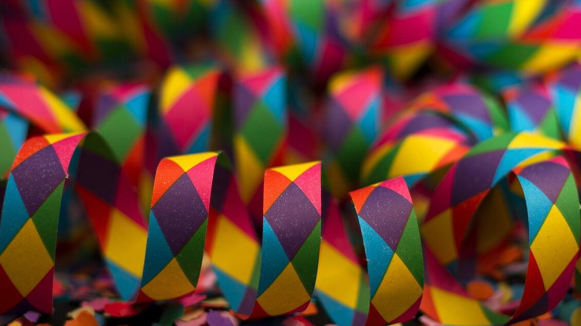 Farbige Papierspiralen in bunten Mustern liegen auf einem Untergrund aus Konfetti. Die fröhlichen Farben verleihen eine festliche Stimmung. | © Pixabay