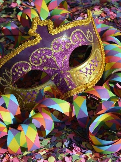 A colorful mask lies on a carpet of confetti. Colorful strings are scattered around, spreading a festive mood. | © Pixabay