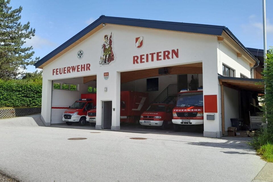 Ein Feuerwehrhaus in Reitern mit mehreren Einsatzfahrzeugen. Im Hintergrund ist eine grüne Landschaft zu sehen. | © Loitzl Franz