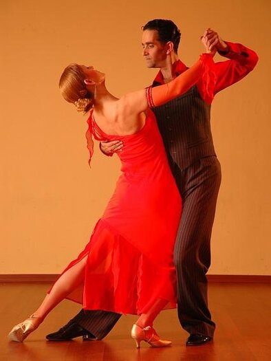 Ein Paar tanzt leidenschaftlich im Tango-Stil. Die Frau trägt ein rotes Kleid, während der Mann elegante Kleidung hat. | © pixabay