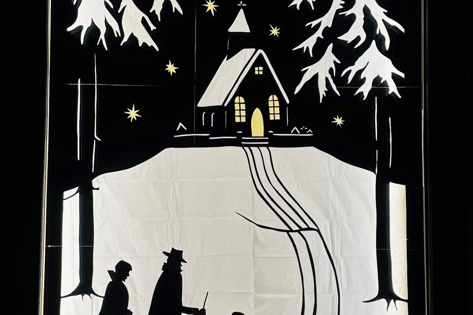 Eine winterliche Szene mit zwei Personen und einem Kind, die auf einem schneebedeckten Weg zu einer kleinen Kirche gehen. Umgeben von Tannenbäumen und einem klaren Nachthimmel mit funkelnden Sternen. | © Elisabeth Winter