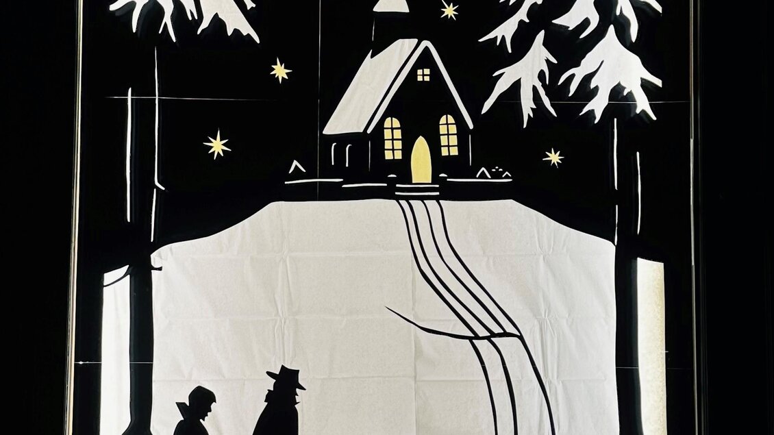 Eine winterliche Szene mit zwei Personen und einem Kind, die auf einem schneebedeckten Weg zu einer kleinen Kirche gehen. Umgeben von Tannenbäumen und einem klaren Nachthimmel mit funkelnden Sternen. | © Elisabeth Winter