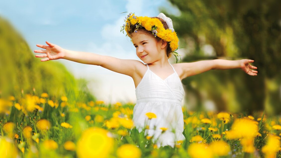 Mädchen inmitten eines Felds voller Löwenzahnblüten im Naturpark Almenland | © Tourismusverband Oststeiermark