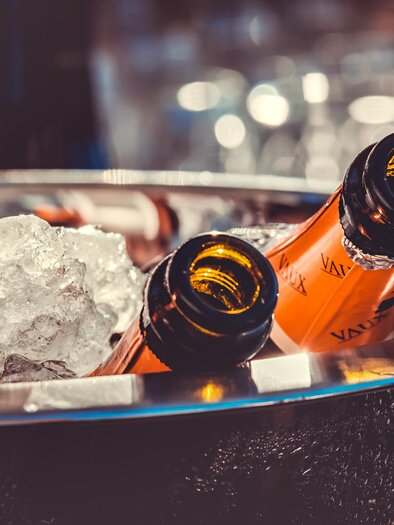 Eine Kühlbox mit Sektflasche, umgeben von Eis. Die Flaschen sind stilvoll in einem eleganten Container platziert. | © pixabay.com