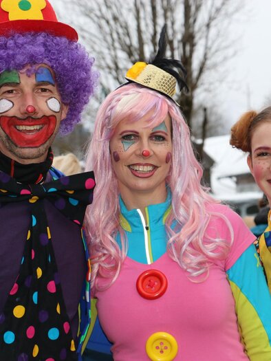 Drei fröhliche Clowns stehen zusammen auf einem festlichen Ereignis. Sie tragen bunte Kostüme und haben einladende Lächeln. | © TVB Ausseerland Salzkammergut