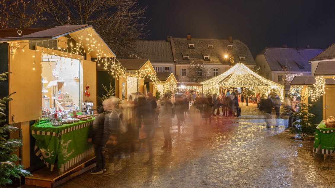 <p>festlich beleuchtete Hütten mit Weihnachtsbäumen und funkelnden Lichtern. Der Boden ist mit Holzspänen bedeckt und schafft eine gemütliche Atmosphäre.</p> | © Tourismusverband Oststeiermark