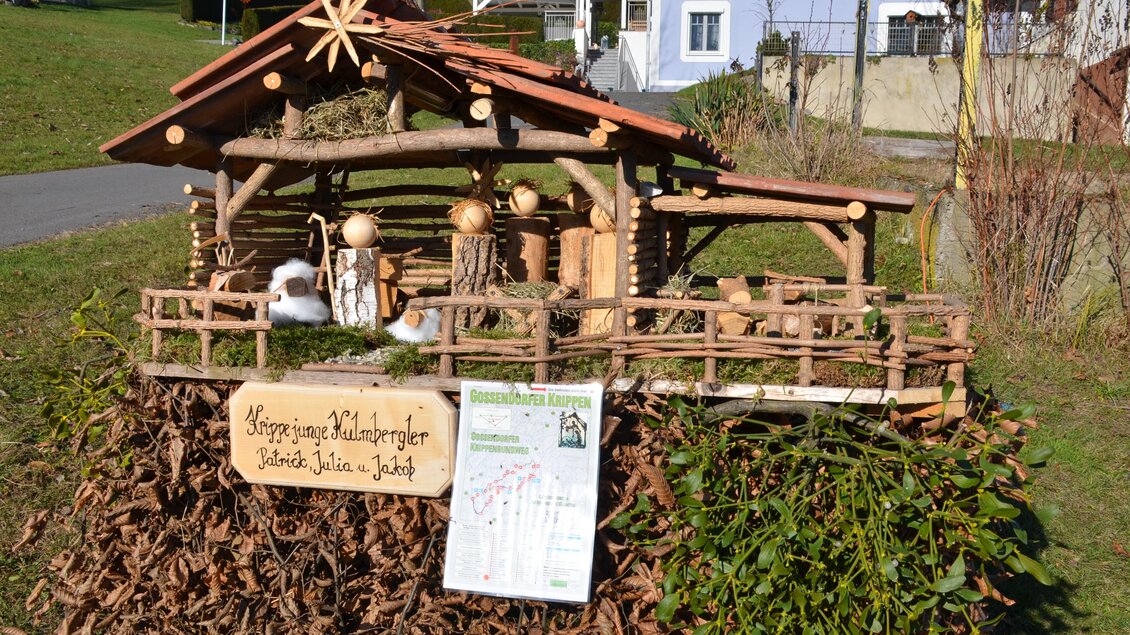 Eine liebevoll gestaltete Weihnachtskrippe aus Holz mit Figuren. Im Hintergrund sind Häuser und grüne Wiesen zu sehen. | © Tourismusverband Thermen- & Vulkanland
