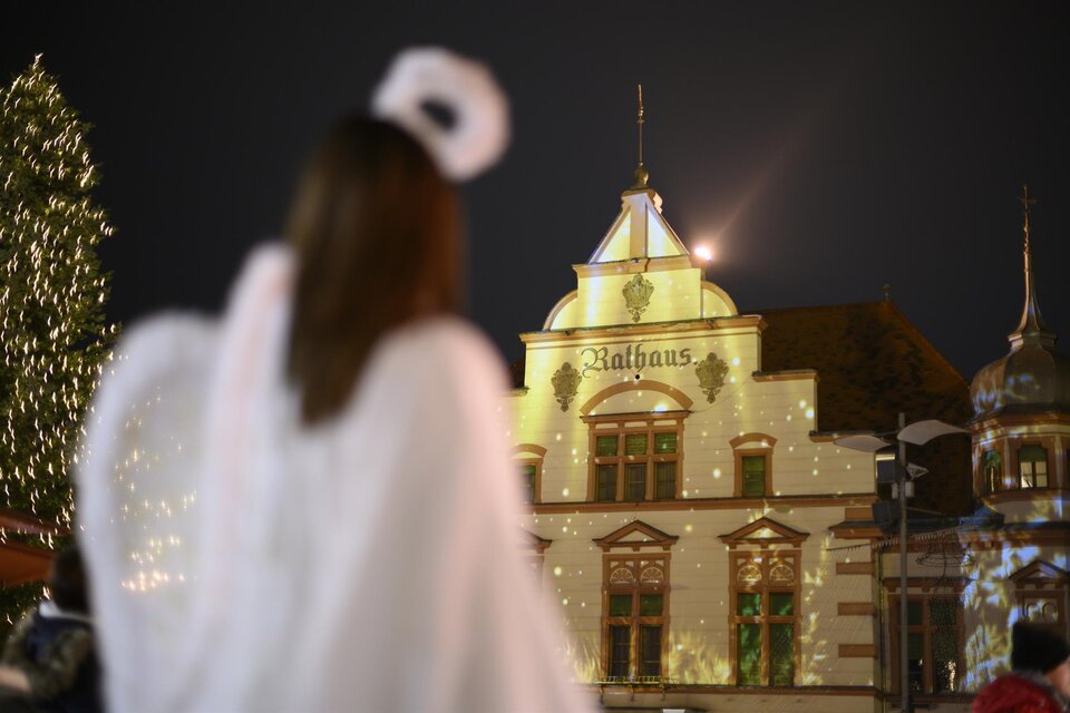 Eine Person in einem weißen Gewand steht vor einem schön dekorierten Gebäude mit festlichen Lichtern. Der Himmel ist dunkel und die Atmosphäre ist weihnachtlich. | © Tourismus Oststeiermark