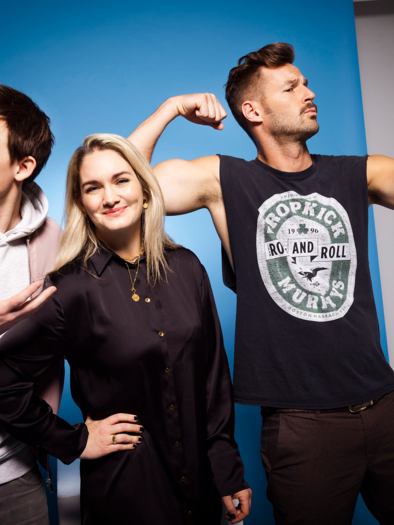 Three people are posing in front of a blue background. One person is taking a selfie while the other two are showing different facial expressions. | © Moritz_Schell.